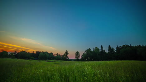 golden sunset to nightfall time lapse over a countryside meadow and picturesque forest