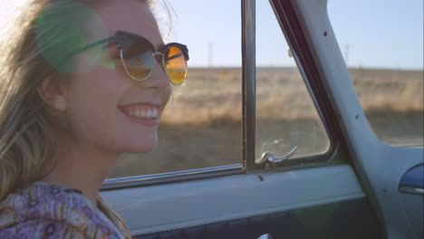 beautiful-blonde-friend-enjoying-road-trip-in-vintage-convertible-car