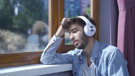 unhappy man listening to music with headphones.