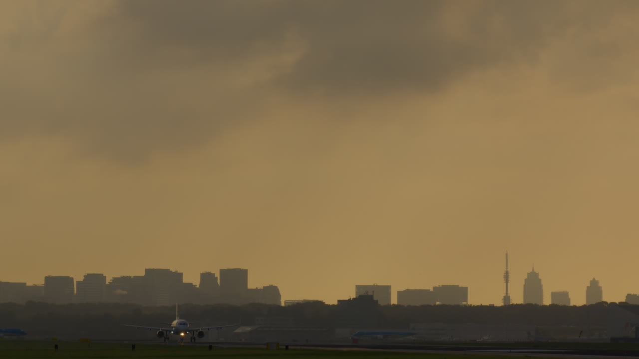도시 위에서 해가 지면 비행기가 착륙하거나 이륙합니다.
