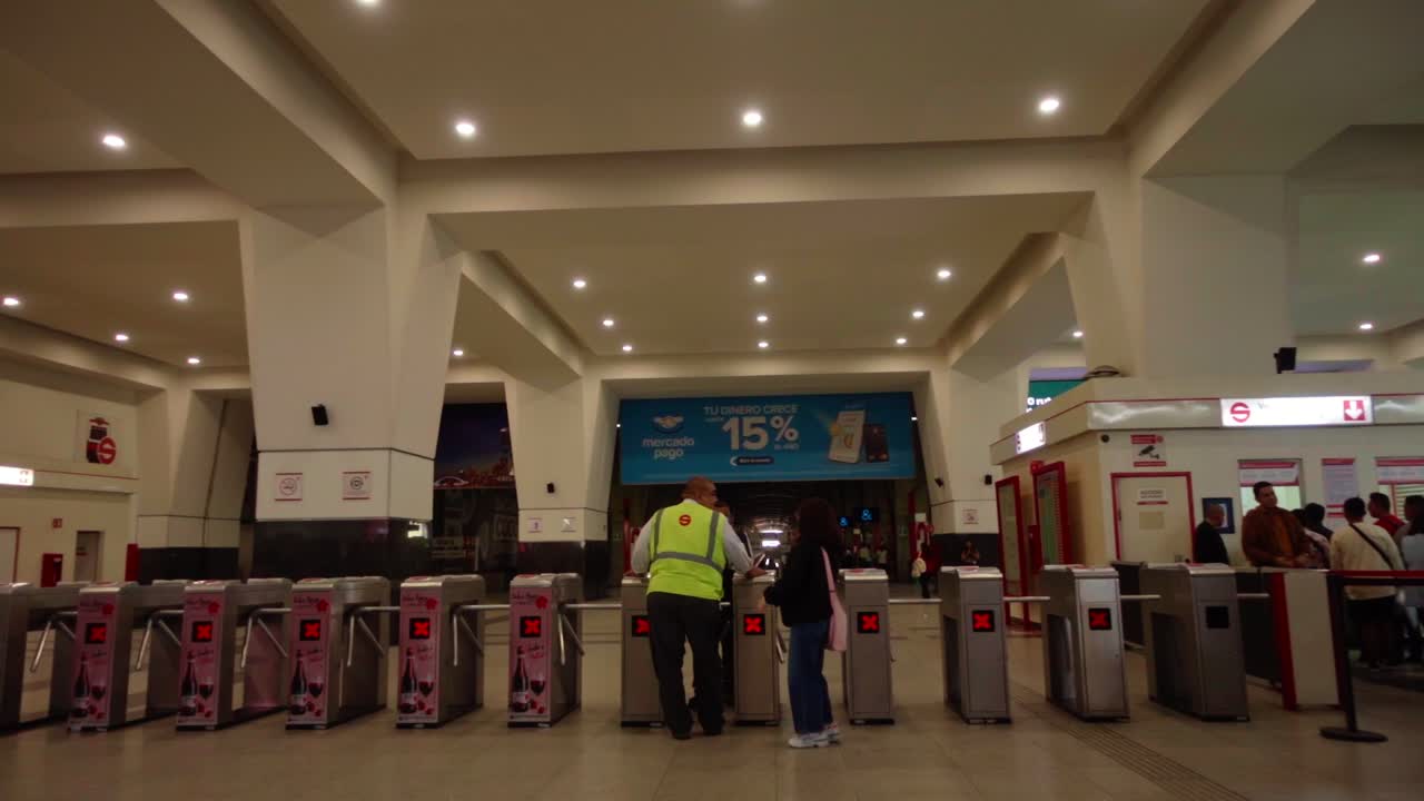Passenger reporting a problem to security officer at the turnstiles of a terminal
