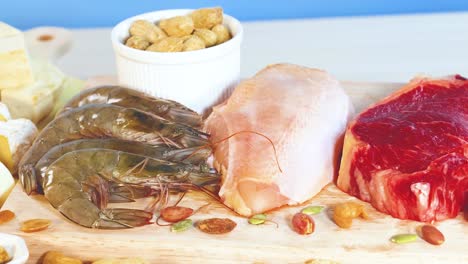 una vibrante exhibición de varios alimentos ricos en proteínas, incluidas carnes, mariscos, nueces y productos lácteos, dispuestos en una superficie de madera