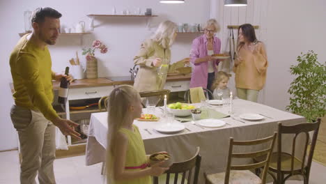 happy family, with parents, grandmothers and little girls, setting the table together and being ready to have dinner 1