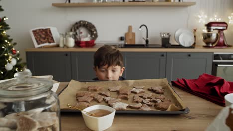 zoom en el video de un niño robando galletas de pan de jengibre de la mesa