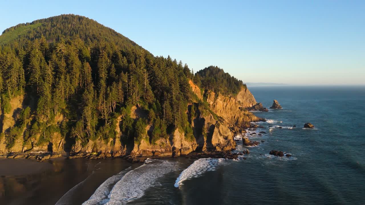 Filmagem de drone acompanhando a Costa do Oregon para a esquerda ao pôr do sol.