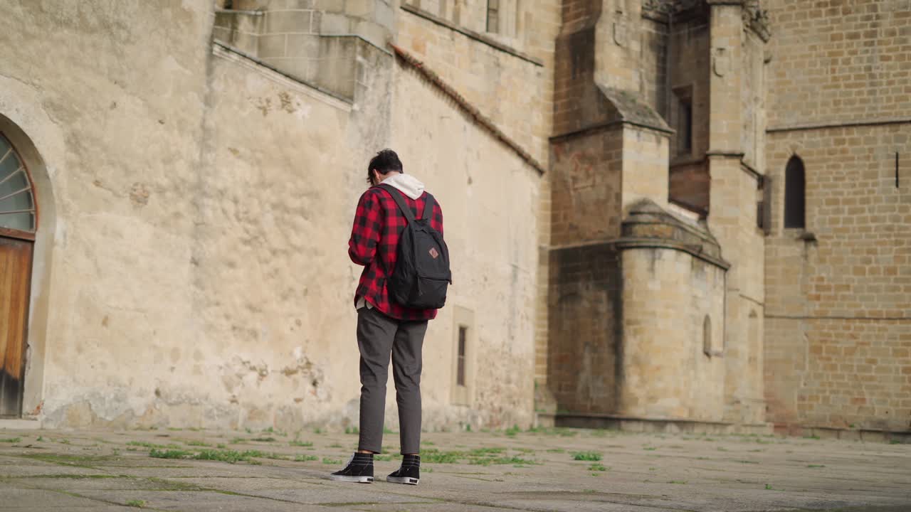 지도를 살펴보고 고대 건물 근처에서 전화를 받는 관광객