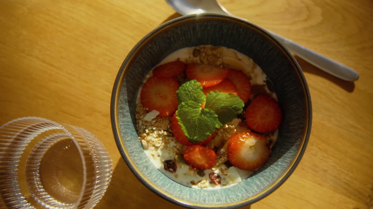 yogur de primera con granola casera y fresas decoradas con menta en un hermoso tazón