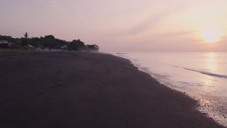 Drohne-Fliegt-Bei-Sonnenaufgang-über-Den-Strand-Von-Goa-Lawah,-Bali,-Indonesien,-Aus-Der-Luft