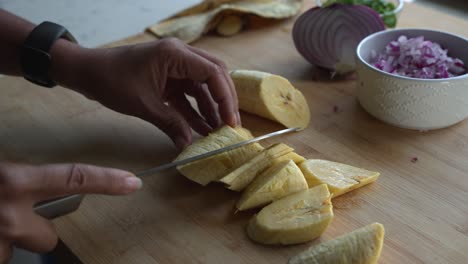 cortar plátano amarillo en pedazos pequeños e ingredientes especiales para cocinar una comida dos latas de frijoles arroz plátano aguacate cebolla roja y cilantro