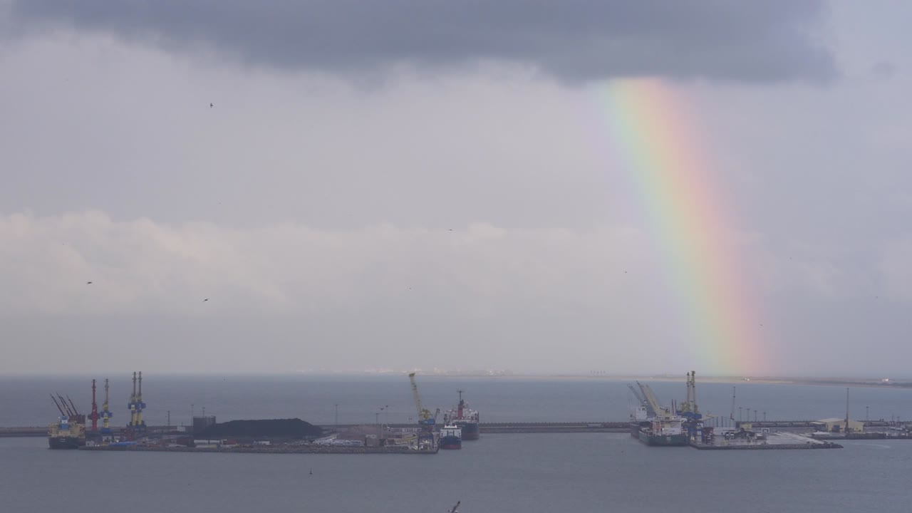 arco iris en un día nublado en el puerto de melilla