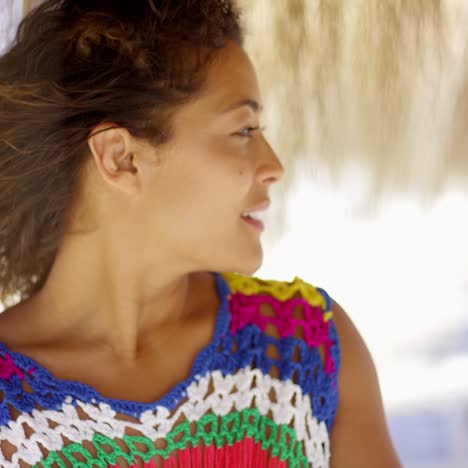 serious woman under thatch beach umbrella