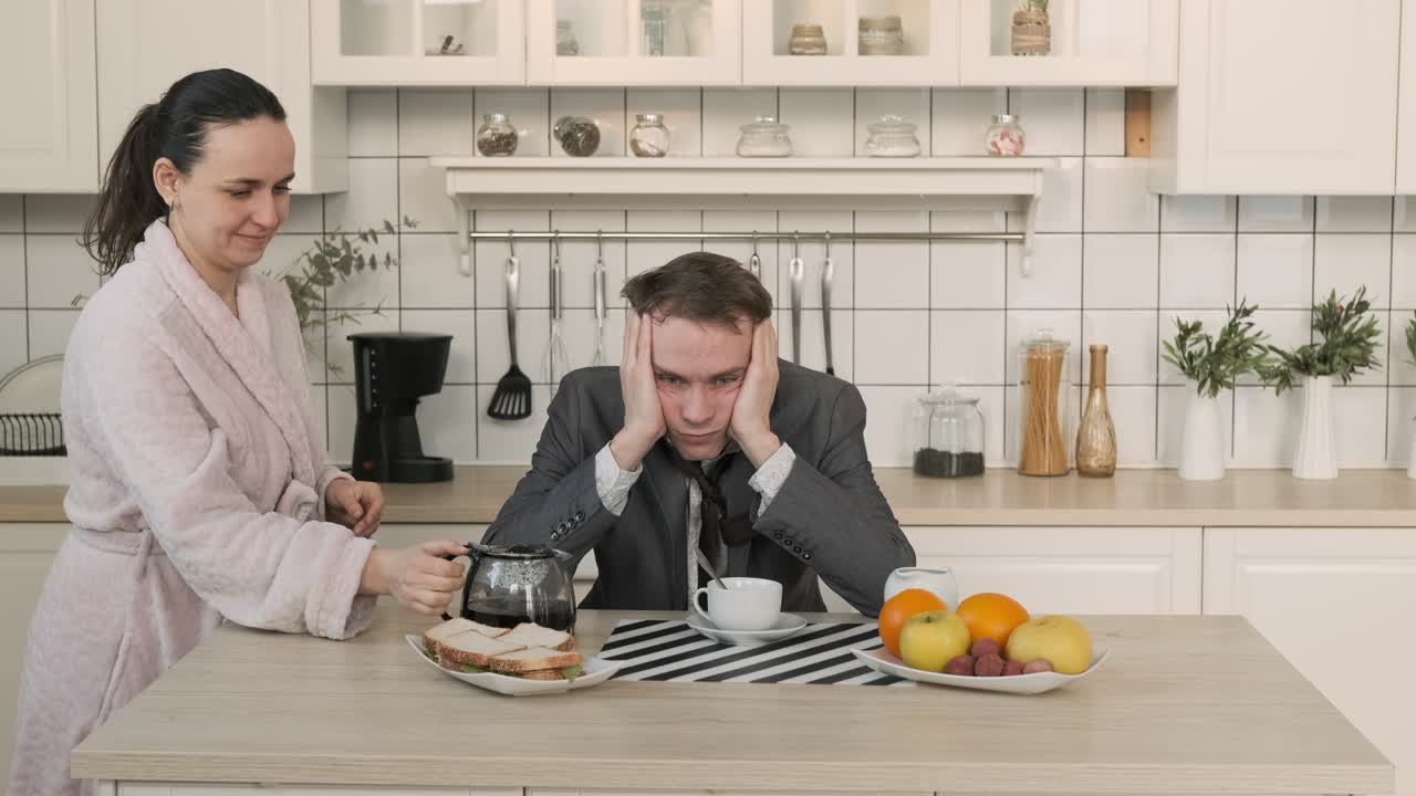 Udmattet mand drikker fra kaffekande derhjemme