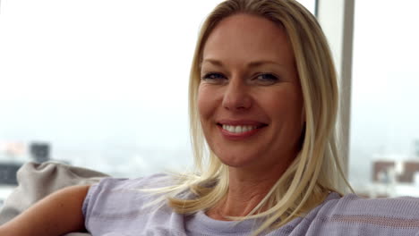 woman smiling at camera on sofa