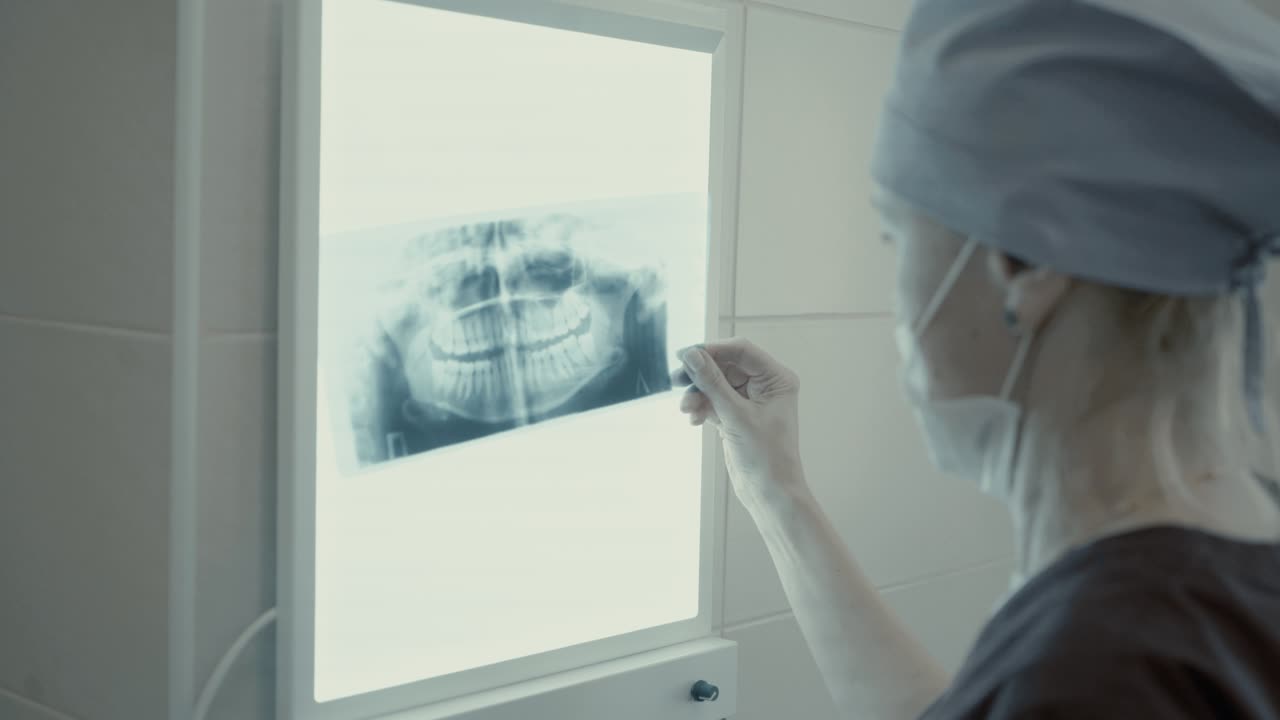 Woman dentist looking xray jaw