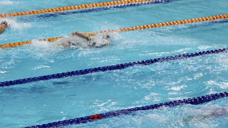 swimmers racing in a pool during a competition