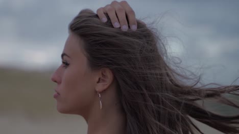 Dunkelhaarige-Frauen-Mit-Einem-Wilden-Starren-Wind,-Der-Durch-Ihr-Haar-Weht,-In-Einer-Malerischen-Wolkenlandschaft-In-Filmischer-Zeitlupe