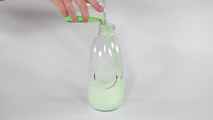 Green liquid reacts with baking soda in bottle