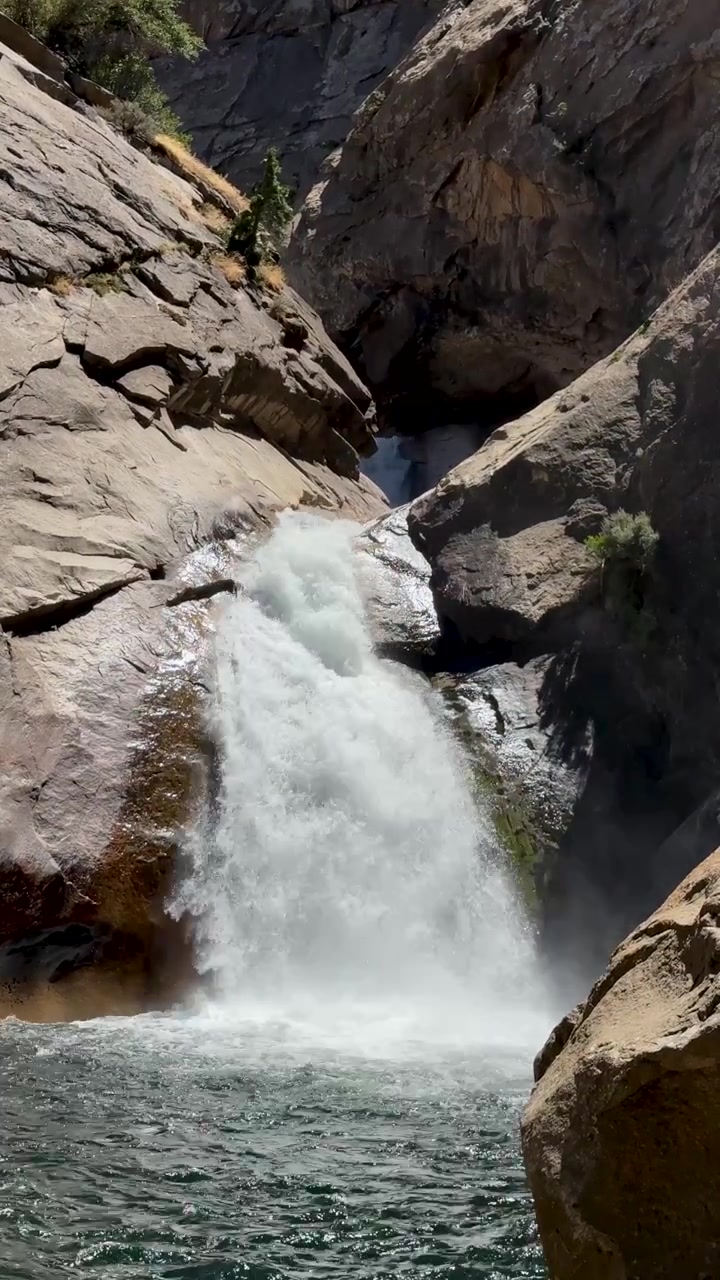 Un'ampia inquadratura verticale di una cascata in un paesaggio roccioso.