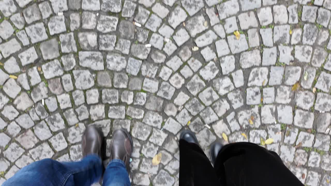Overhead View of Two People Walking on Cobblestone Street