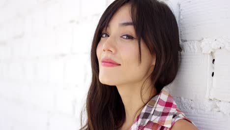 Serene-woman-with-long-brown-hair-stares-at-camera