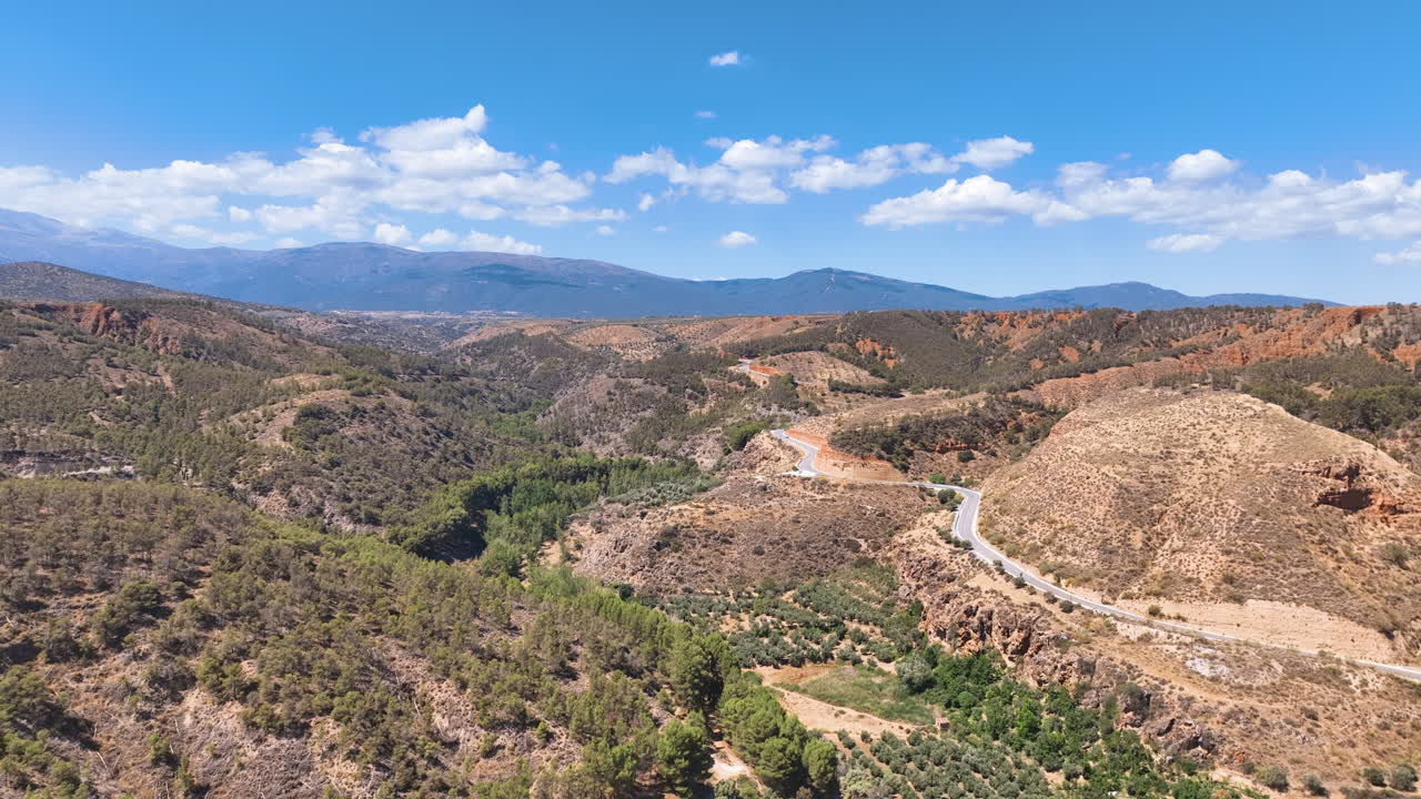 Aerial into the scenic rolling foothills of Spain's Sierra Nevada mountains