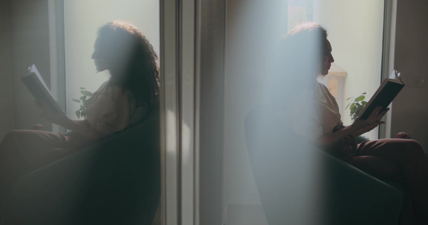 Woman reading with her reflection behind