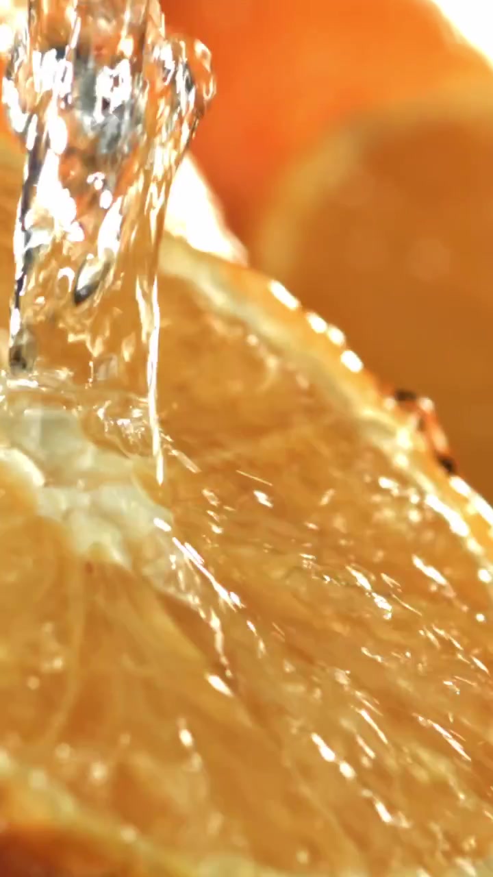Acqua rinfrescante che si versa su una fetta d'arancia fresca al rallentatore