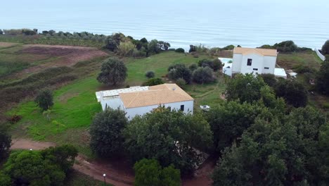 gran vuelo de drones aéreos curva panorámica de vuelo de drones disparados alrededor de una casa de campo y un barco en un acantilado