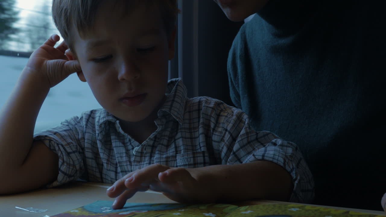 niño y madre leyendo un libro para niños en el tren
