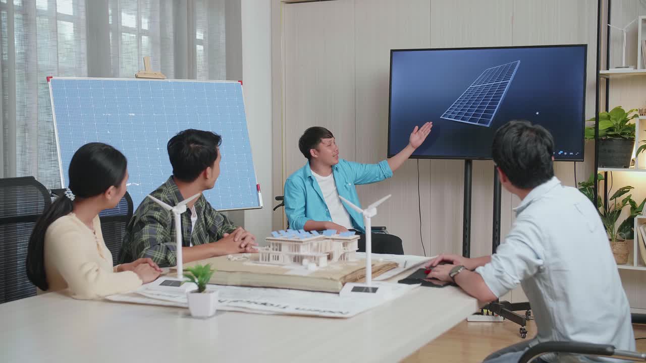 체어에 앉은 아시아인 엔지니어가 사무실에서 태양전지 작업에 대해 성공적으로 발표하면서 관객들은 박수를 치며 인상적 느낌을 받았습니다.