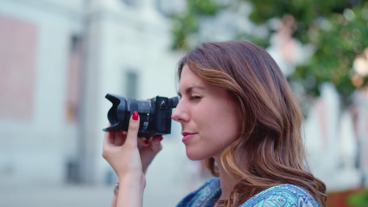 Young woman taking photos with a camera outdoors