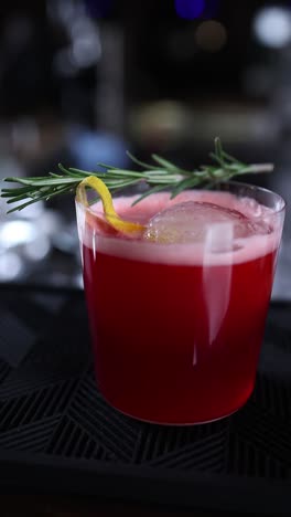 red cocktail with rosemary and lemon