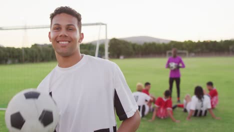 video of biracial player with diverse group of male football player on field