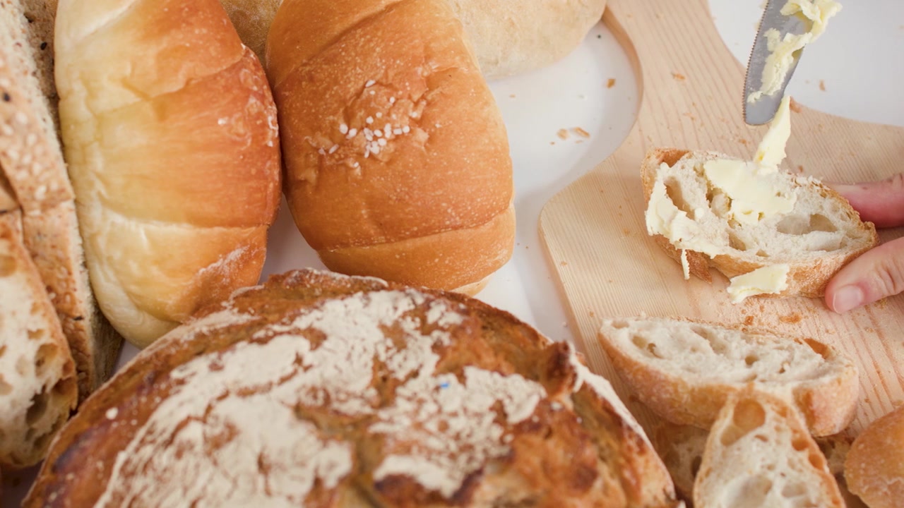 Spreading Butter on a Slice of Fresh Crusty Bread