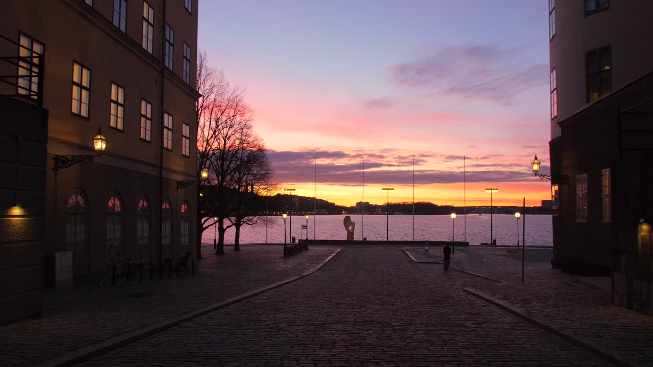 panorámica a través de la colorida puesta de sol durante el disparo del amanecer desde el casco antiguo de gamla stan en estocolmo, suecia