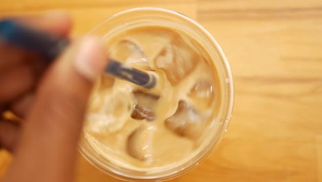 hand stirring iced coffee