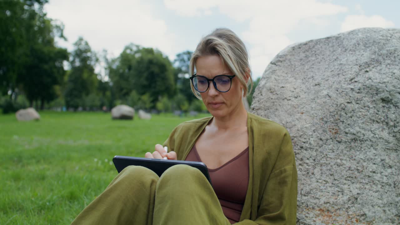 Woman using tablet in park