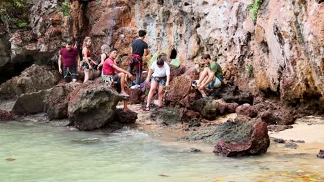 group preparing for rock climbing by the sea