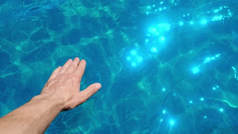 hand touching the turquoise water