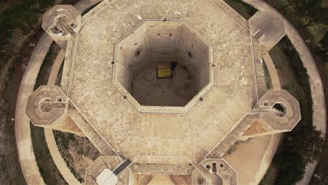 drone flying over above castel del monte flying backwards with the camera tilting up in the south of italy in 4k