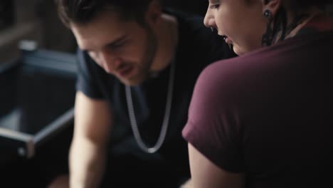 Caucasian-man-and-woman-discussing-about-new-tattoos.