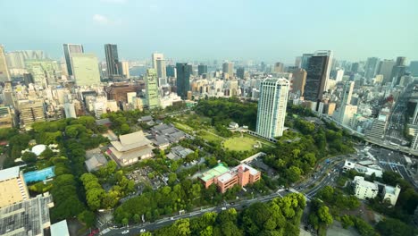 Drone-like-static-wide-angle-view-over-looking-east-on-a-hazy-summer-day-with-temple-and-traffic-below-midday