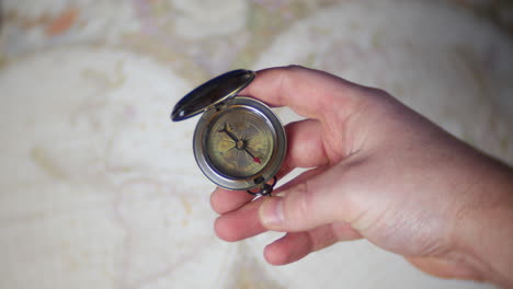 a man uses an antique cbrass compass