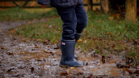 close up of girl splashing in puddle shot in slow motion