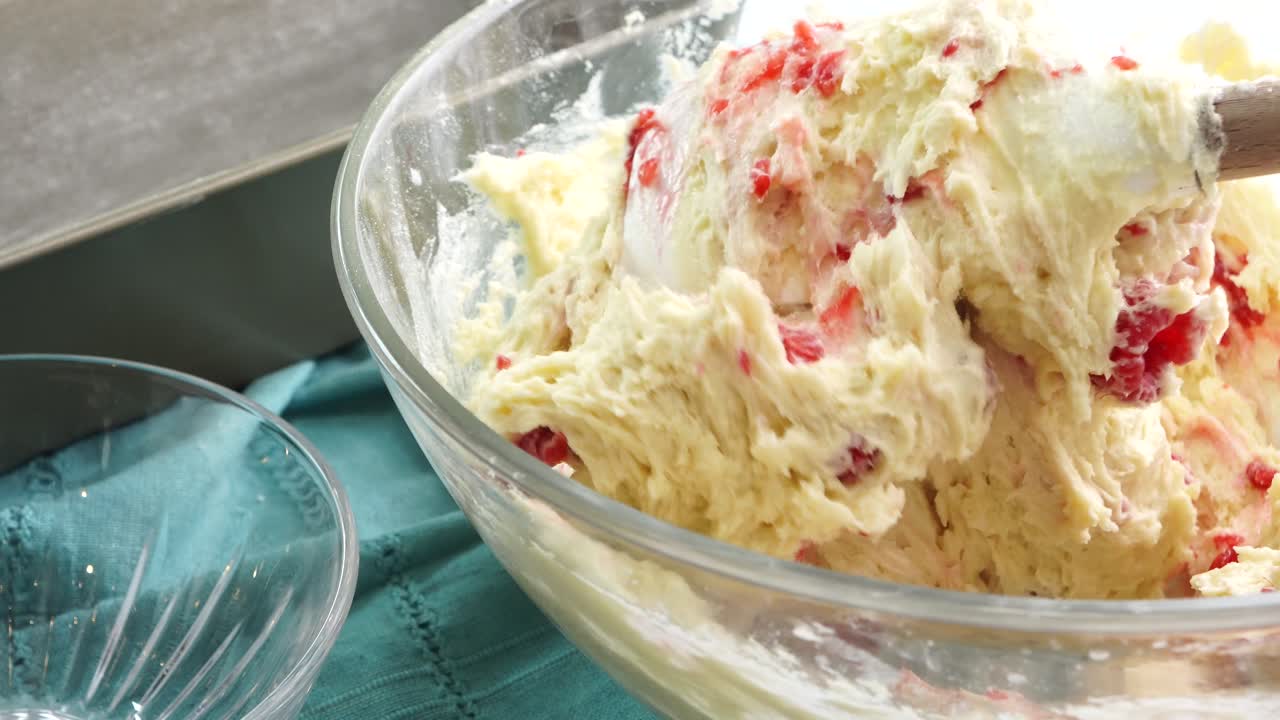 Making a dessert called Red Raspberry Tea Cake made with fresh berries and vanilla buttercream frosting. Great for Tea Parties. Adding into the batter, fresh red raspberries and mixing into the bowl