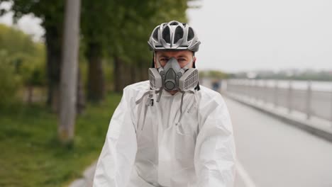 close-up of a young man in a protective suit, mask and helmet rides a bicycle