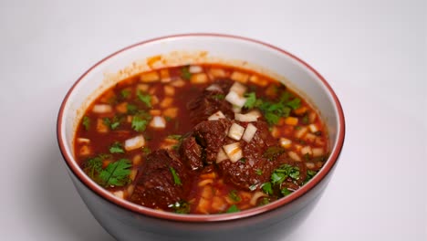 birria soup with garnish on lazy susan