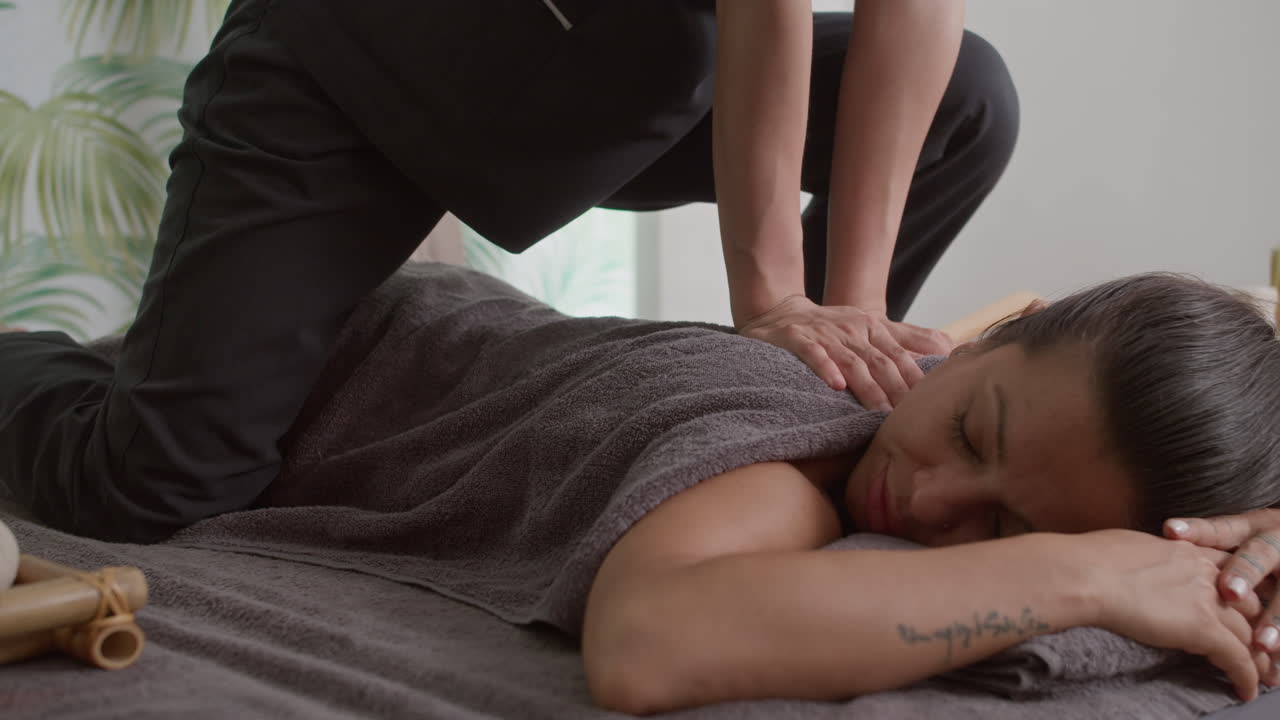 Ukendelig osteopat masserer kvinde og sætter hendes knogler på plads