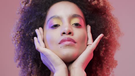 biracial woman with dark hair touching on purple background, slow motion