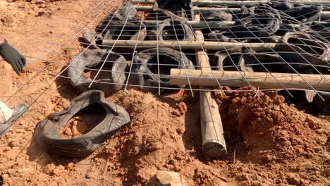 Farm employees in Africa use recycled car tires and gum tree poles to stop erosion, showcasing innovative and sustainable farming techniques in rural outlying areas
